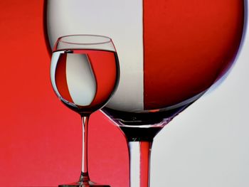 Close-up of beer glass against red background