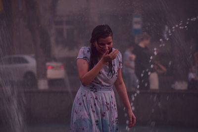 Full length of woman standing in rain