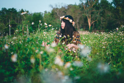 Close-up of woman on plants on field