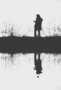 Reflection of woman in lake