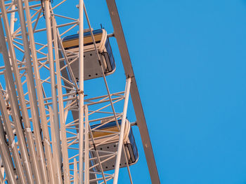 Low angle view of ferris wheel against clear blue sky