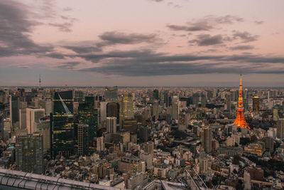 Aerial view of buildings in city against cloudy sky