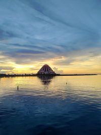 Scenic view of bay against sky at sunset