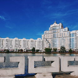 Buildings in city against blue sky