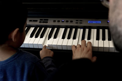 Midsection of man playing piano