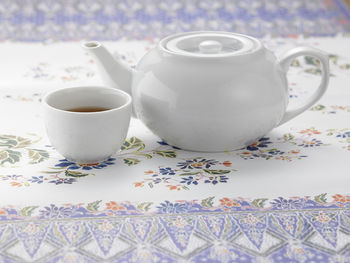 Close-up of teapot and cup on table