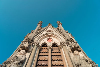 Low angle view of ornate building against clear blue sky