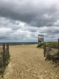 Wooden posts on beach against sky