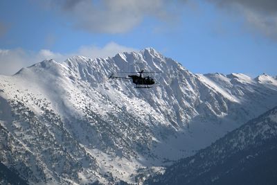 Helicopter flying over snowcapped mountain