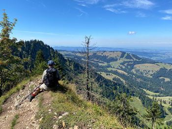 Hiker resting on the top of the hill overlooking the allgäu area