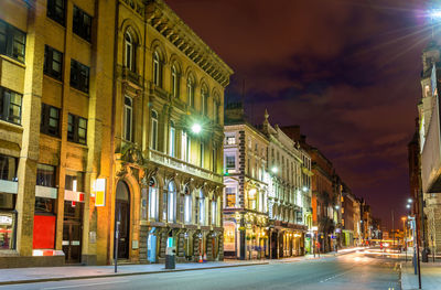 Illuminated city street and buildings at night