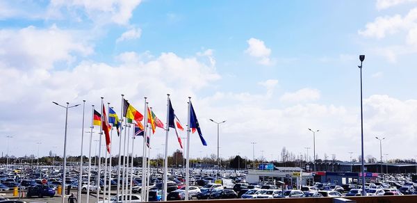 Panoramic view of flags on beach against sky