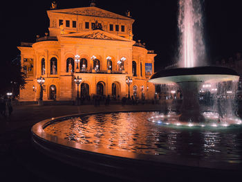 Old opera house of frankfurt at night with beautiful lit up fountain