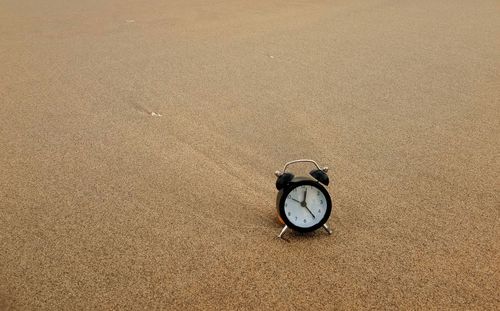 High angle view of clock on sand at beach