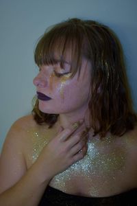 Beautiful woman covered in glitter and glitter tears 