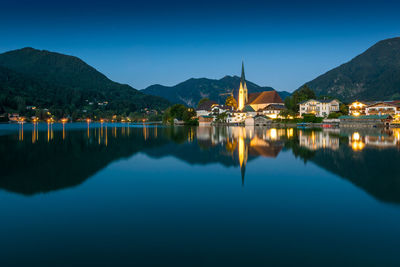 Scenic view of lake and mountains against blue sky