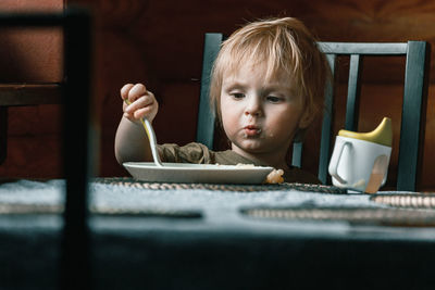 Portrait of cute boy holding table