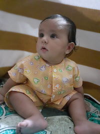 Cute baby boy lying on bed at home