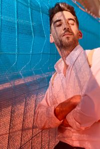 Portrait of man standing by swimming pool