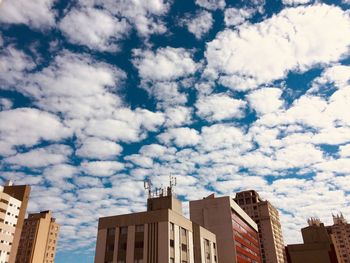 Low angle view of buildings against cloudy sky