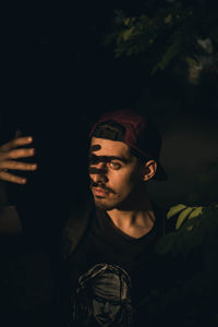 High angle view of young man with hand raised standing by trees