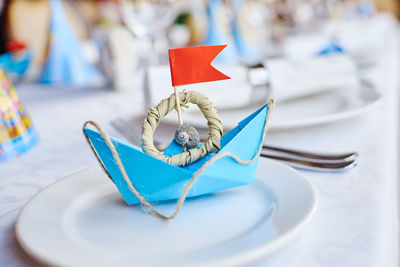 Close-up of paper boat in plate on table