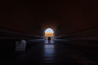 Rear view of people walking in archway