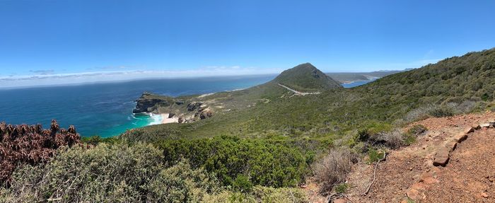 Scenic view of sea and mountains against blue sky