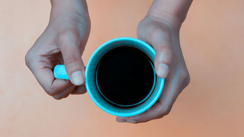 Low section of person holding coffee cup