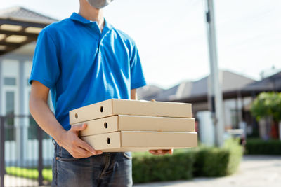 Midsection of man holding camera while standing in box