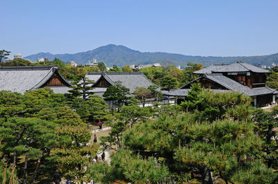 Houses by trees and mountains against clear sky