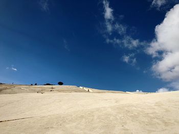 Scenic view of desert against blue sky