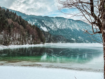 Scenic view of lake by mountains during winter