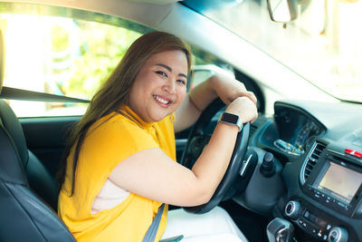 Portrait of smiling young woman in car