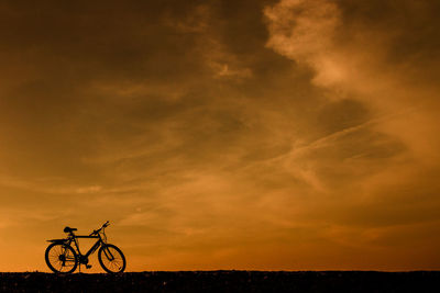 Silhouette bicycle against sky during sunset