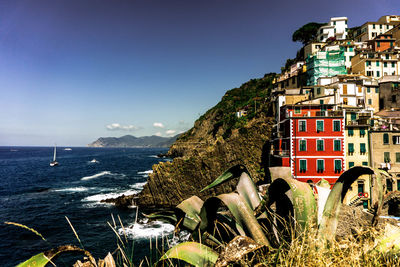 Scenic view of sea by buildings against sky