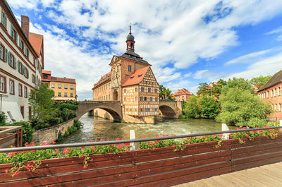 Bridge over canal amidst buildings against sky