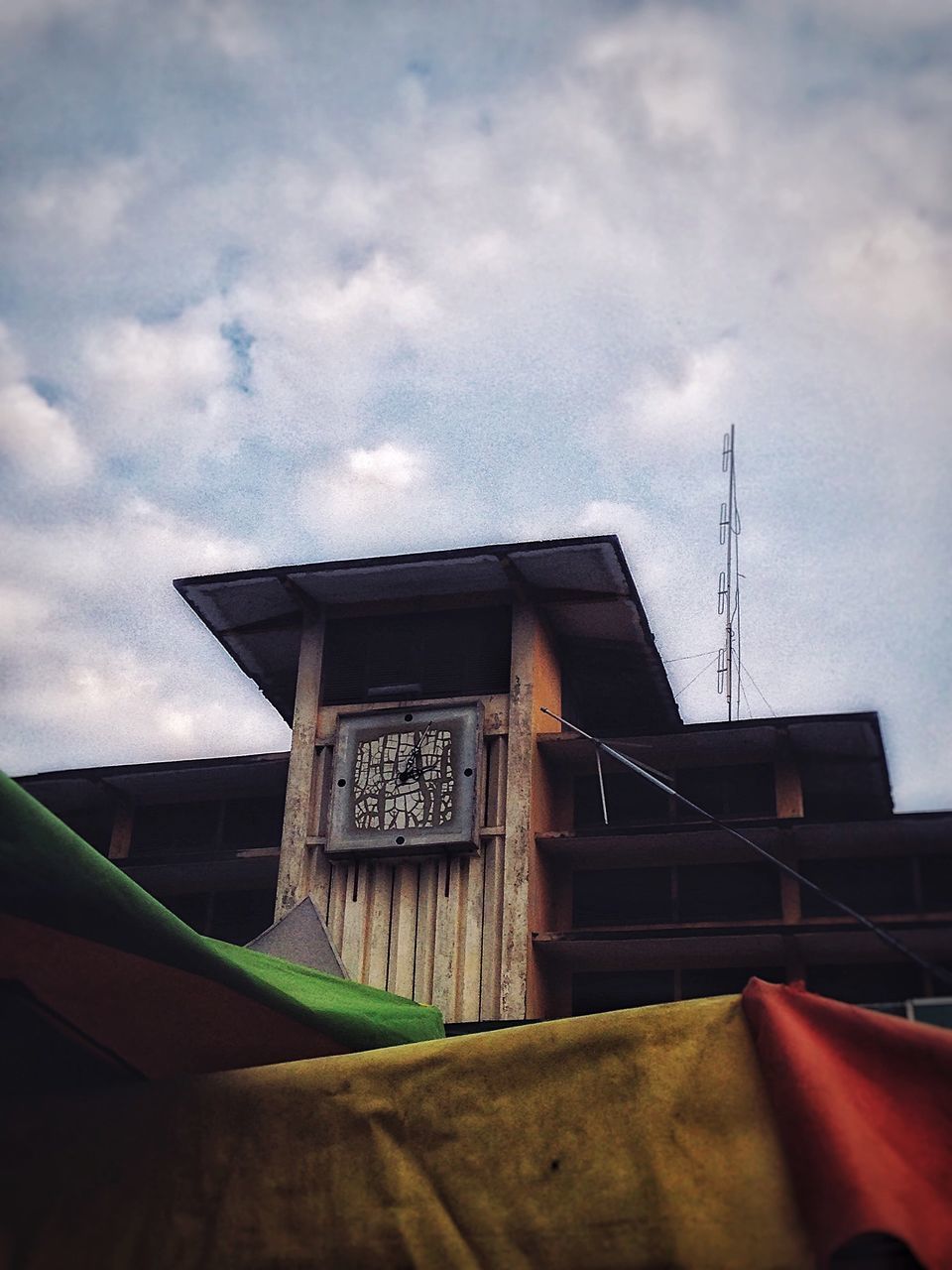 HIGH SECTION OF BUILDING AGAINST CLOUDY SKY