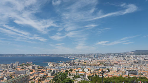 High angle view of townscape by sea against sky