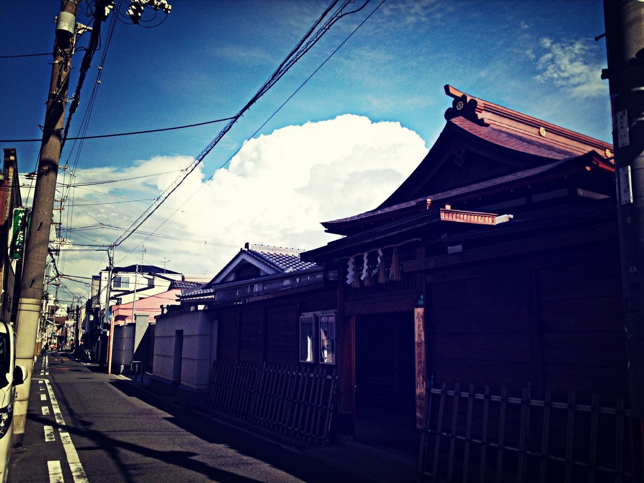 sky, architecture, built structure, building exterior, transportation, cloud - sky, railroad track, cable, power line, cloud, the way forward, rail transportation, public transportation, outdoors, electricity pylon, connection, electricity, railroad station, no people, mode of transport