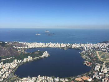 High angle view of cityscape by sea against clear sky