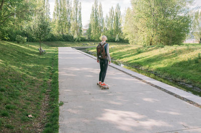 Rear view of woman walking on road