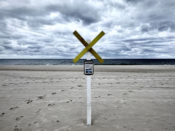 Lifeguard hut on beach against sky