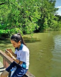 Man using mobile phone by lake