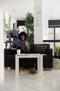 Young woman using laptop while sitting on table