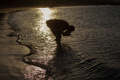 High angle view of silhouette person on sea shore