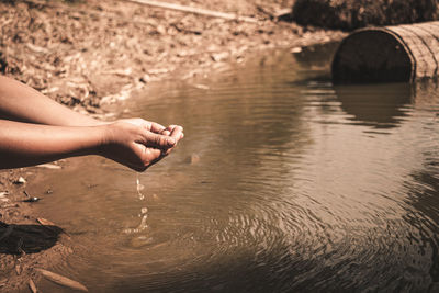 Person hand on rock in river
