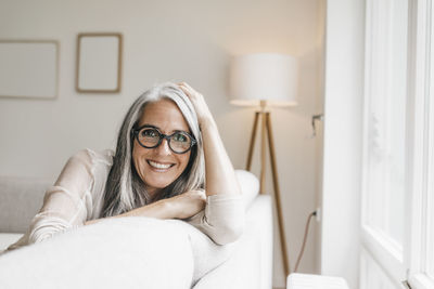 Portrait of smiling woman sitting on the couch at home