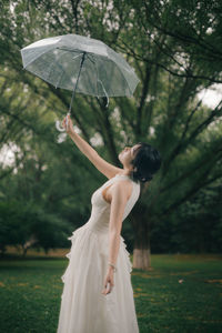 Rear view of woman holding umbrella