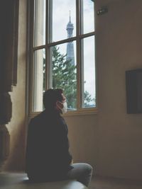 Man looking through window 